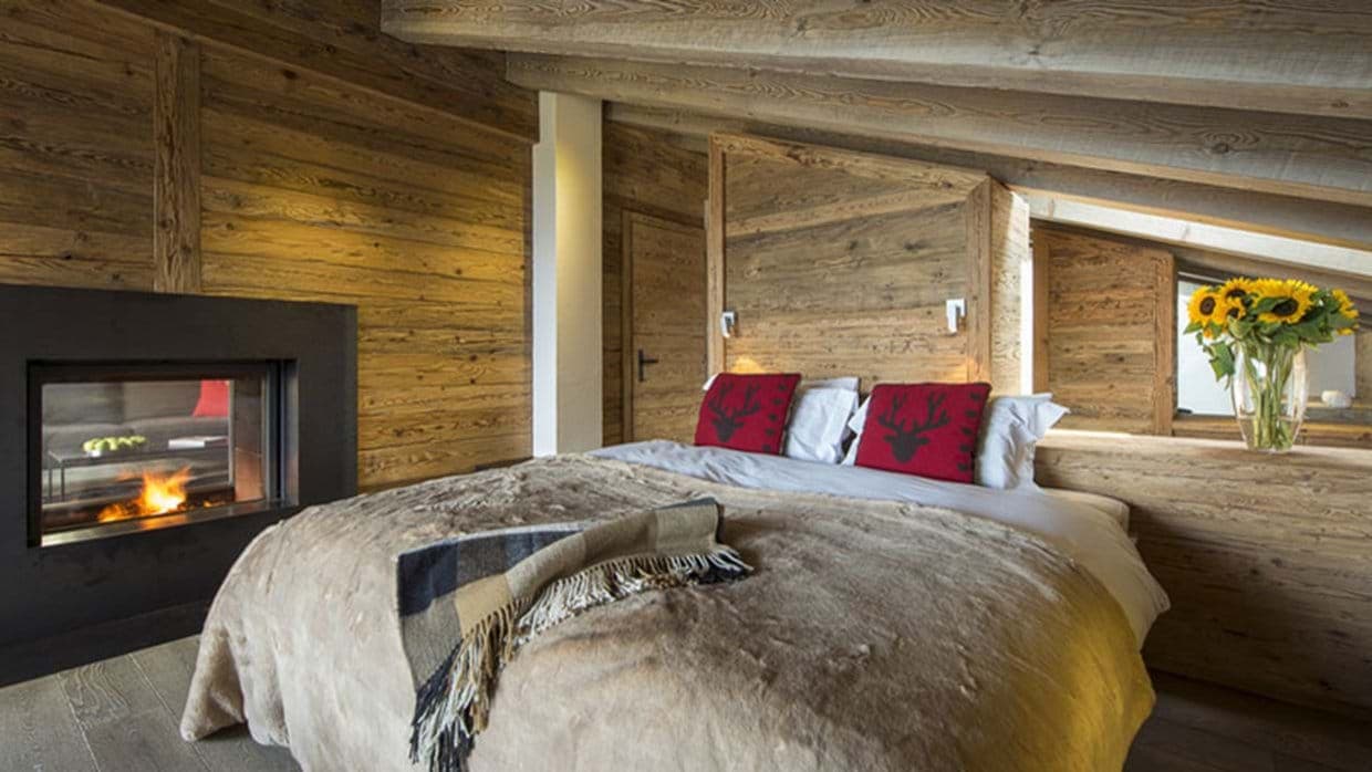 Primary bedroom with king bed and see-through fireplace to living area