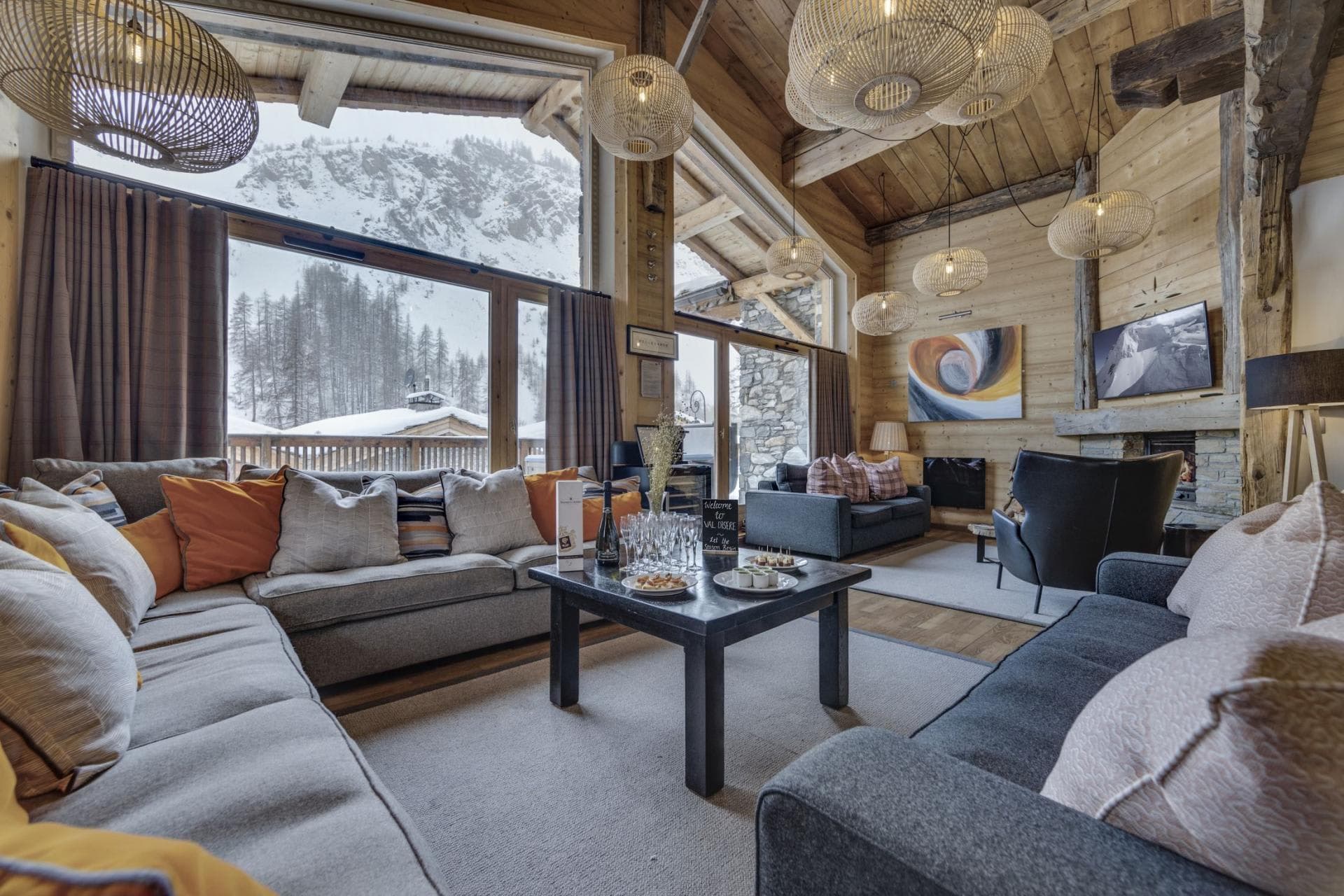 Living area with wood-burning fireplace and floor-to-ceiling mountain views