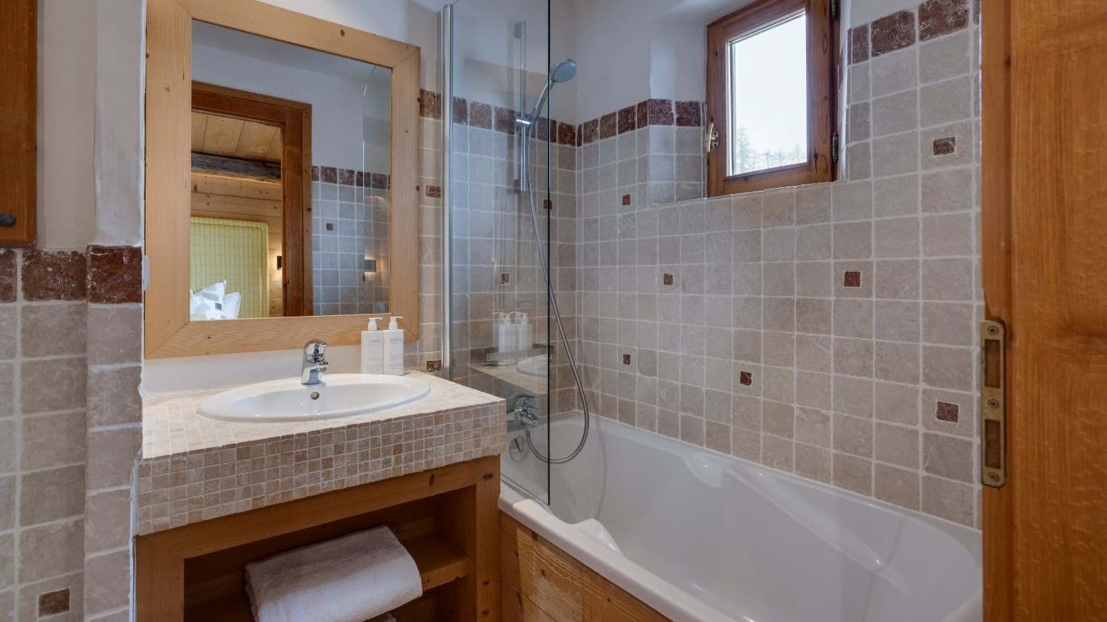 Bathroom with stone tiling and bathtub-shower combination