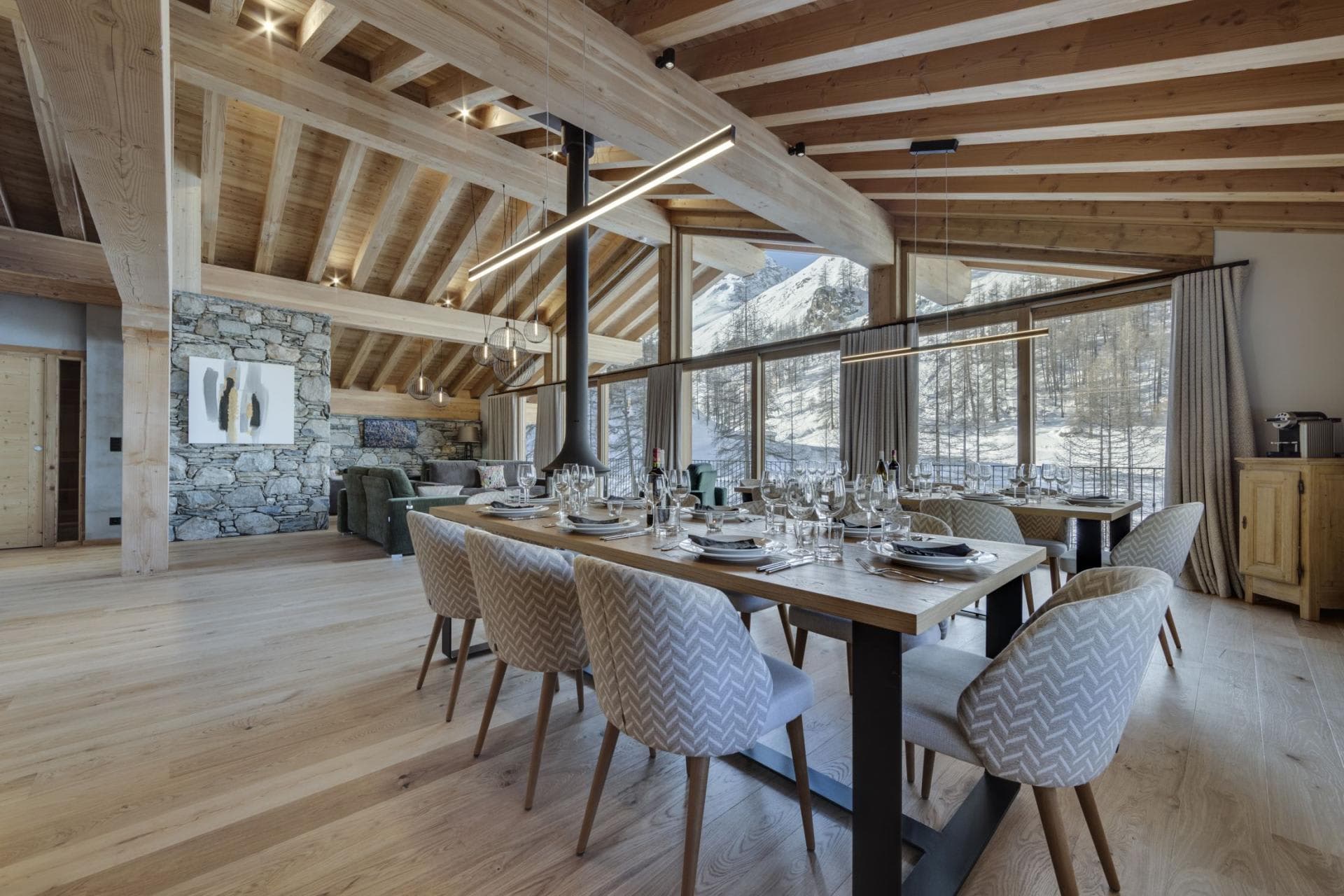 Open-plan dining area seats 10 with floor-to-ceiling mountain views