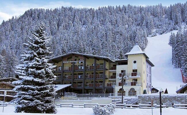 Ski-in/ski-out hotel exterior located directly adjacent to groomed downhill runs