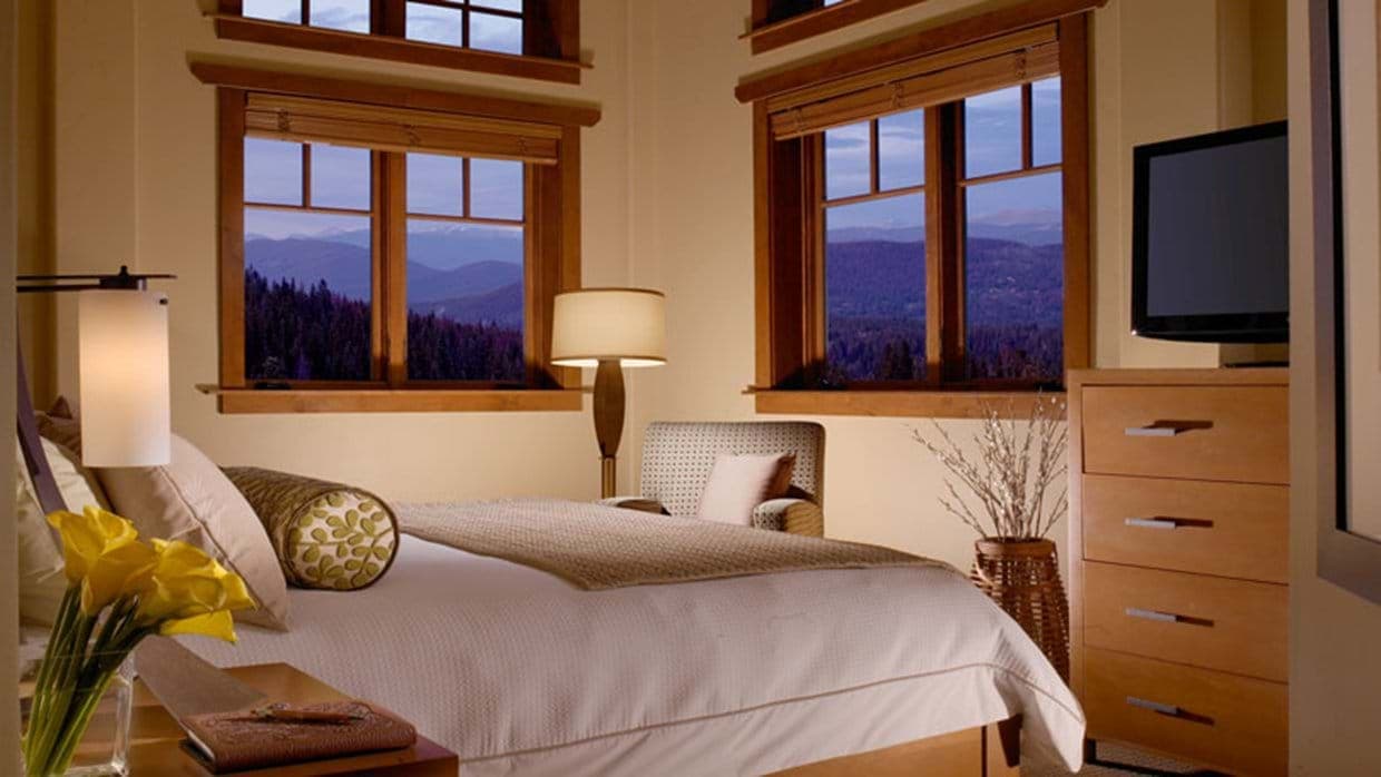 Guest bedroom with mountain views, flat-screen TV, and reading chair