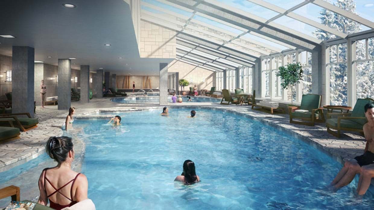 Indoor heated pool with glass roof and adjacent hot tub