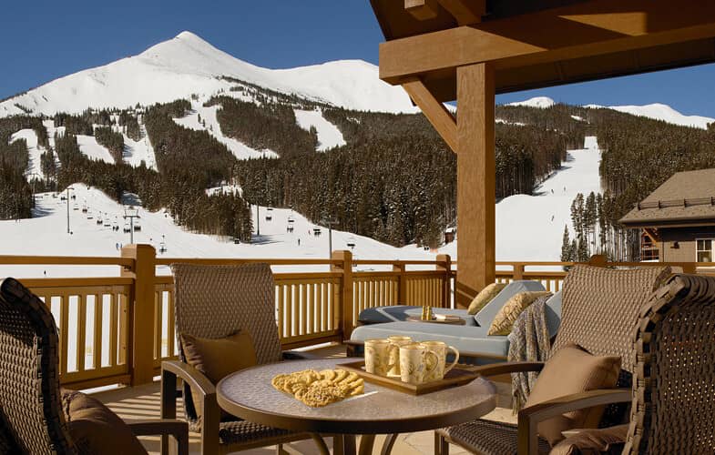 Covered deck with ski-in/ski-out views and cushioned lounge seating