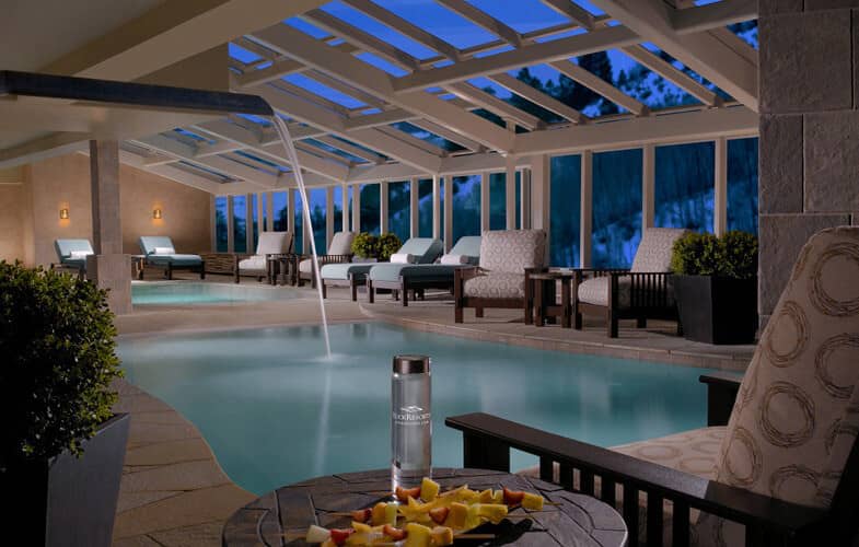 Indoor heated pool with retractable glass roof and waterfall feature