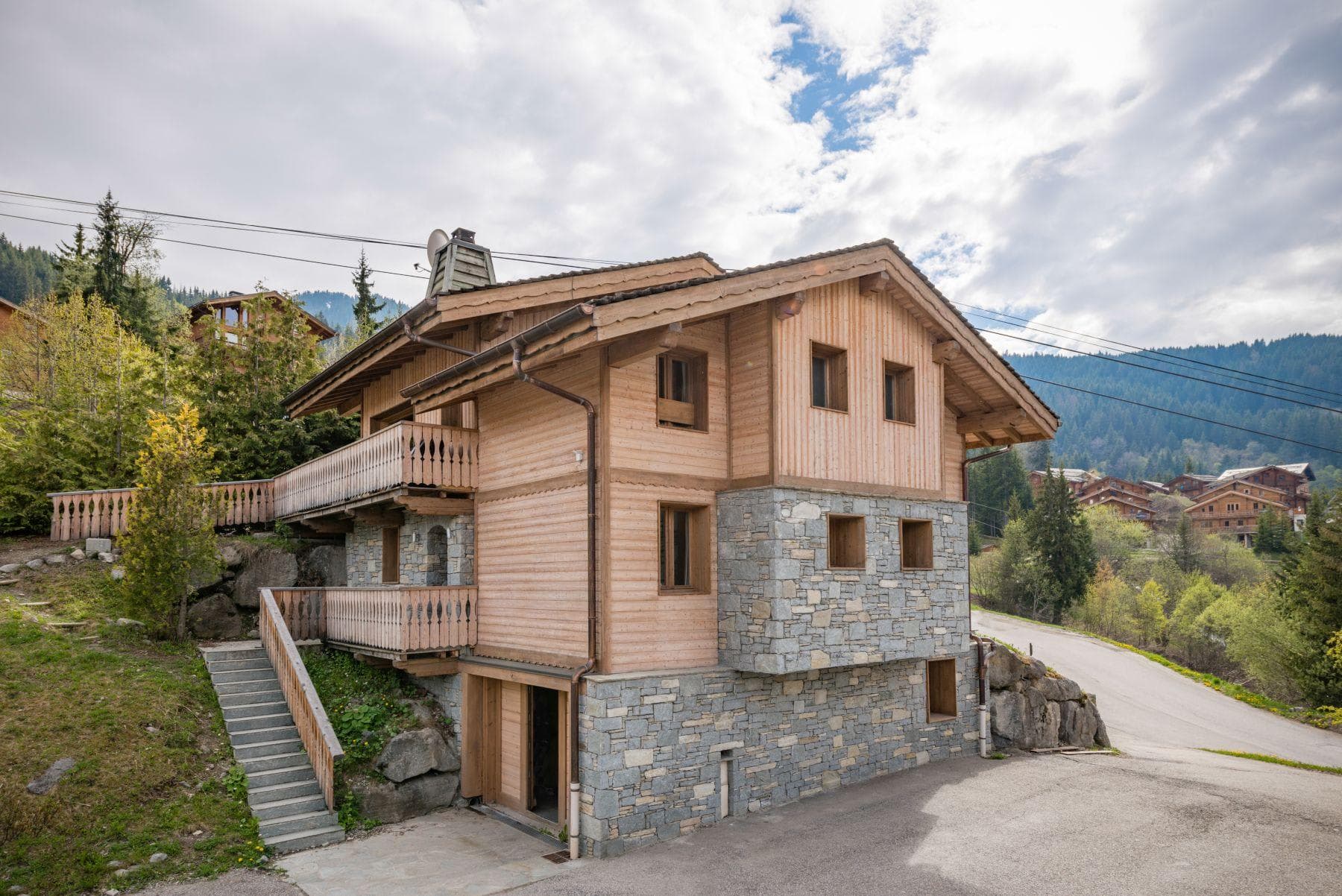 Chalet exterior with two levels of wraparound balconies and ground-level parking