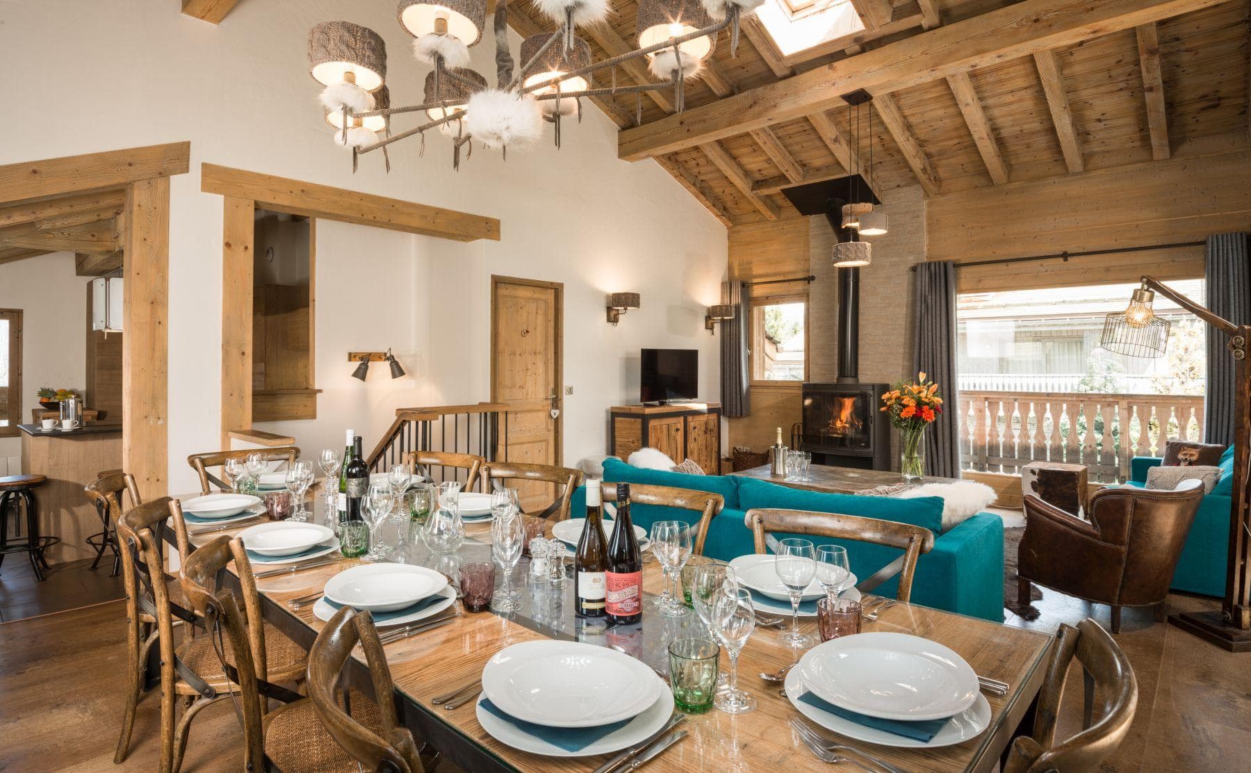 Open-plan dining area for 10 with wood-burning stove and balcony access