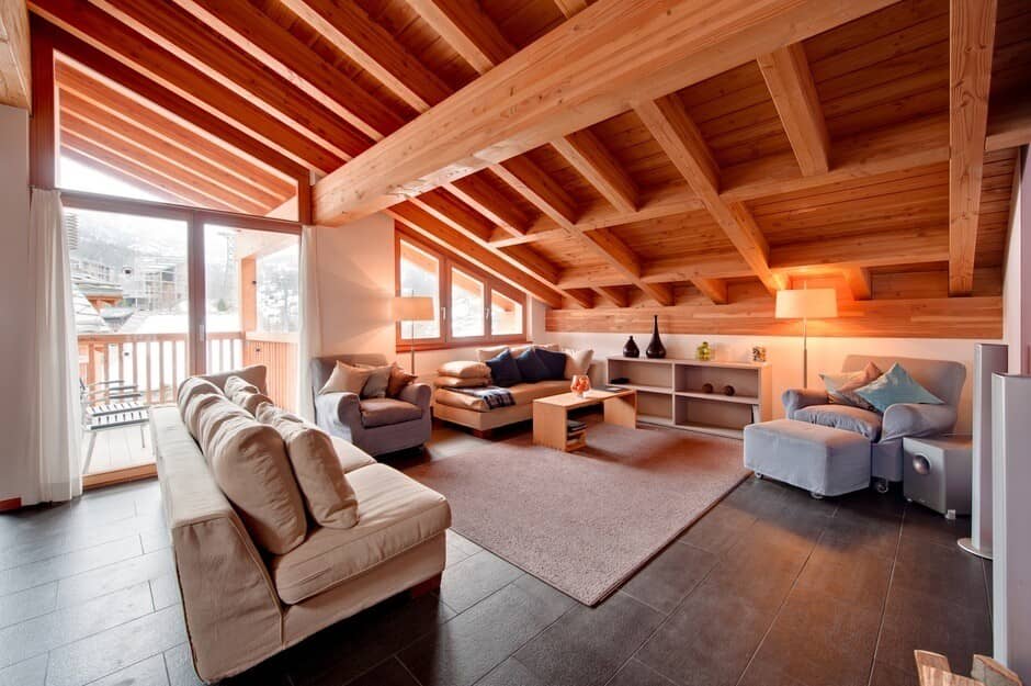 Living area with vaulted timber ceilings and private balcony access