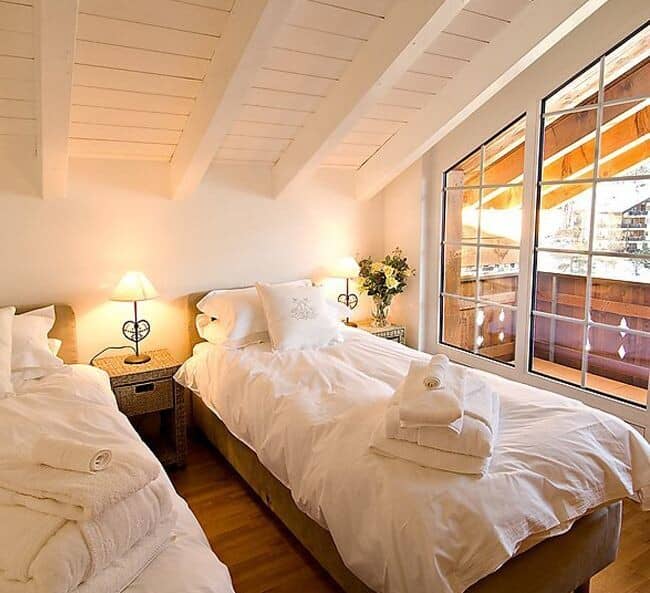 Guest bedroom with twin beds and balcony access