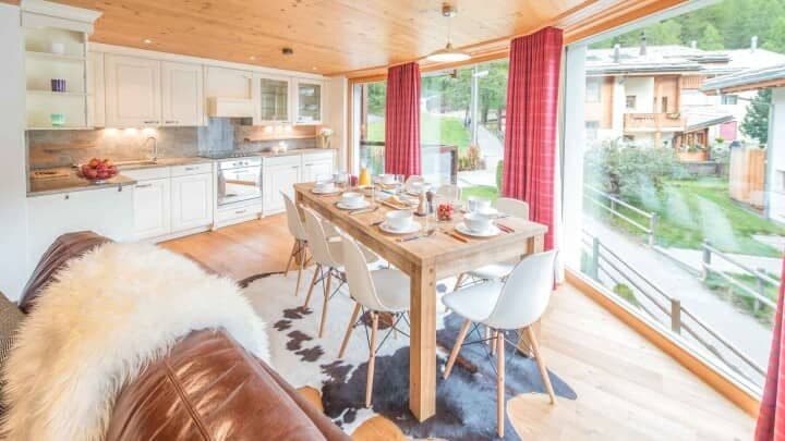 Open-plan kitchen and dining area with seating for 8 and floor-to-ceiling windows