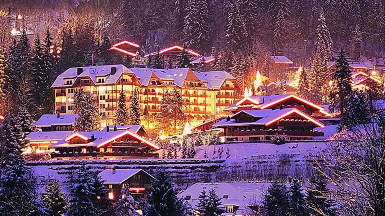 Ski-in, ski-out resort with illuminated chalets and forested mountain views