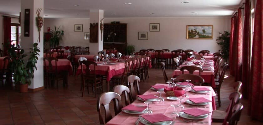 Large dining hall with terracotta floors and banquet seating for 50+