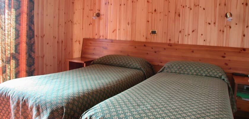 Guest bedroom with two twin beds and pine wood paneling
