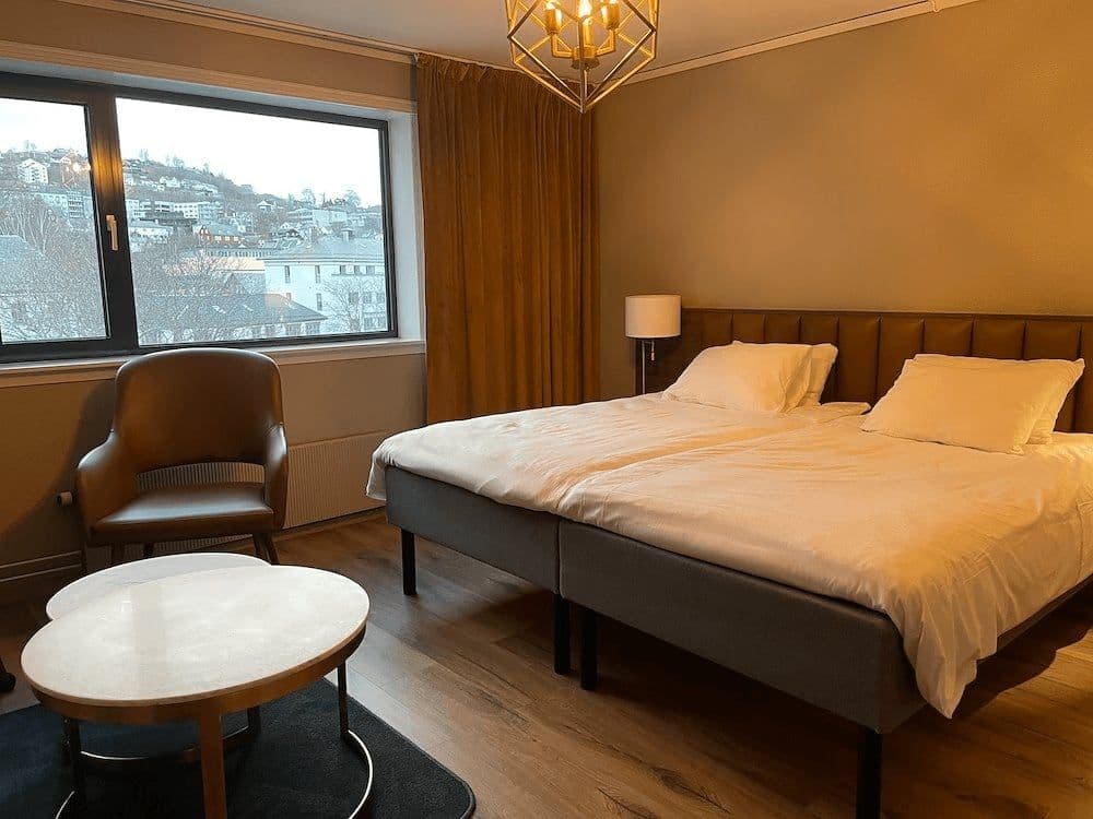 Bedroom with twin beds joined as king and hillside city views