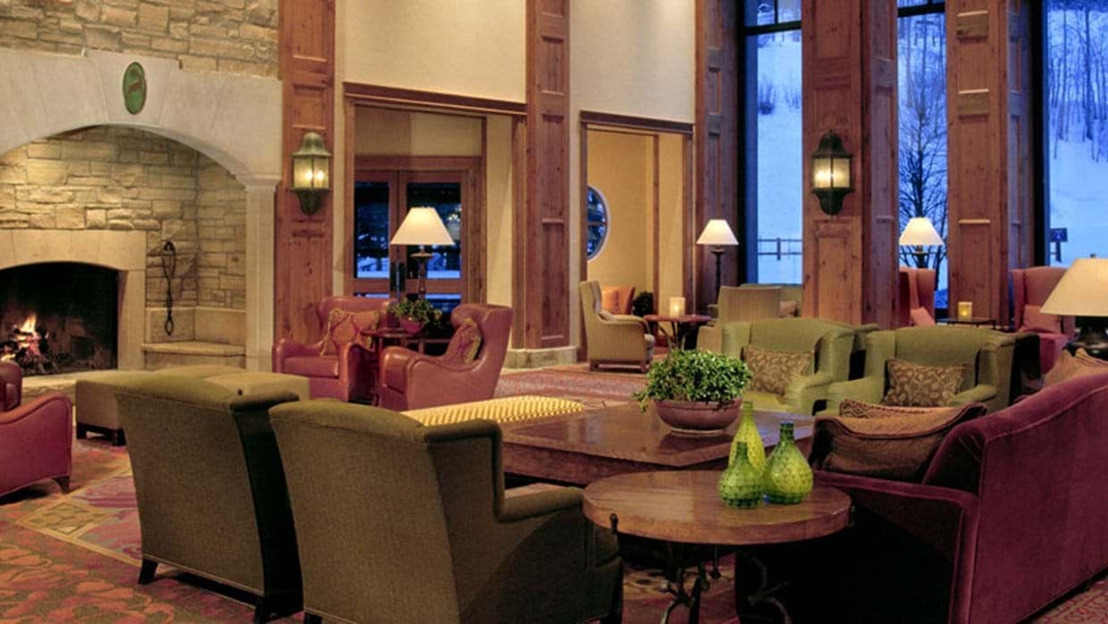 Shared lounge with stone fireplace and floor-to-ceiling ski slope views