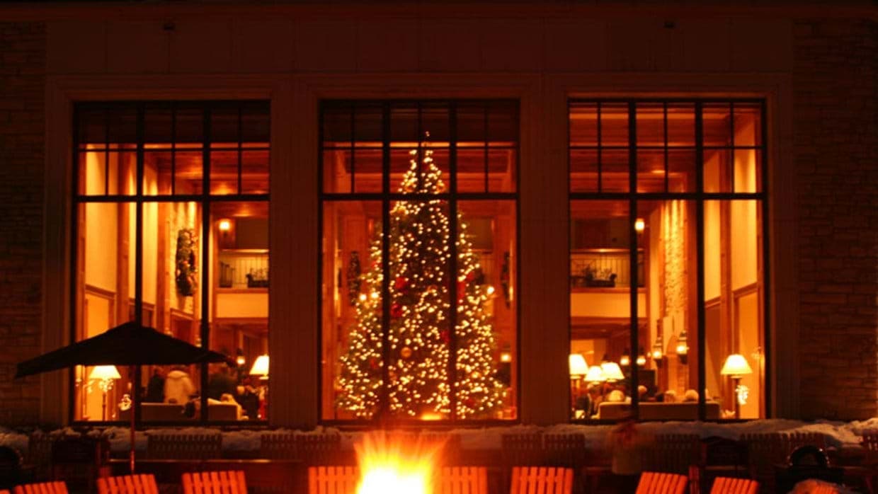 Lodge exterior featuring communal fire pit and floor-to-ceiling windows