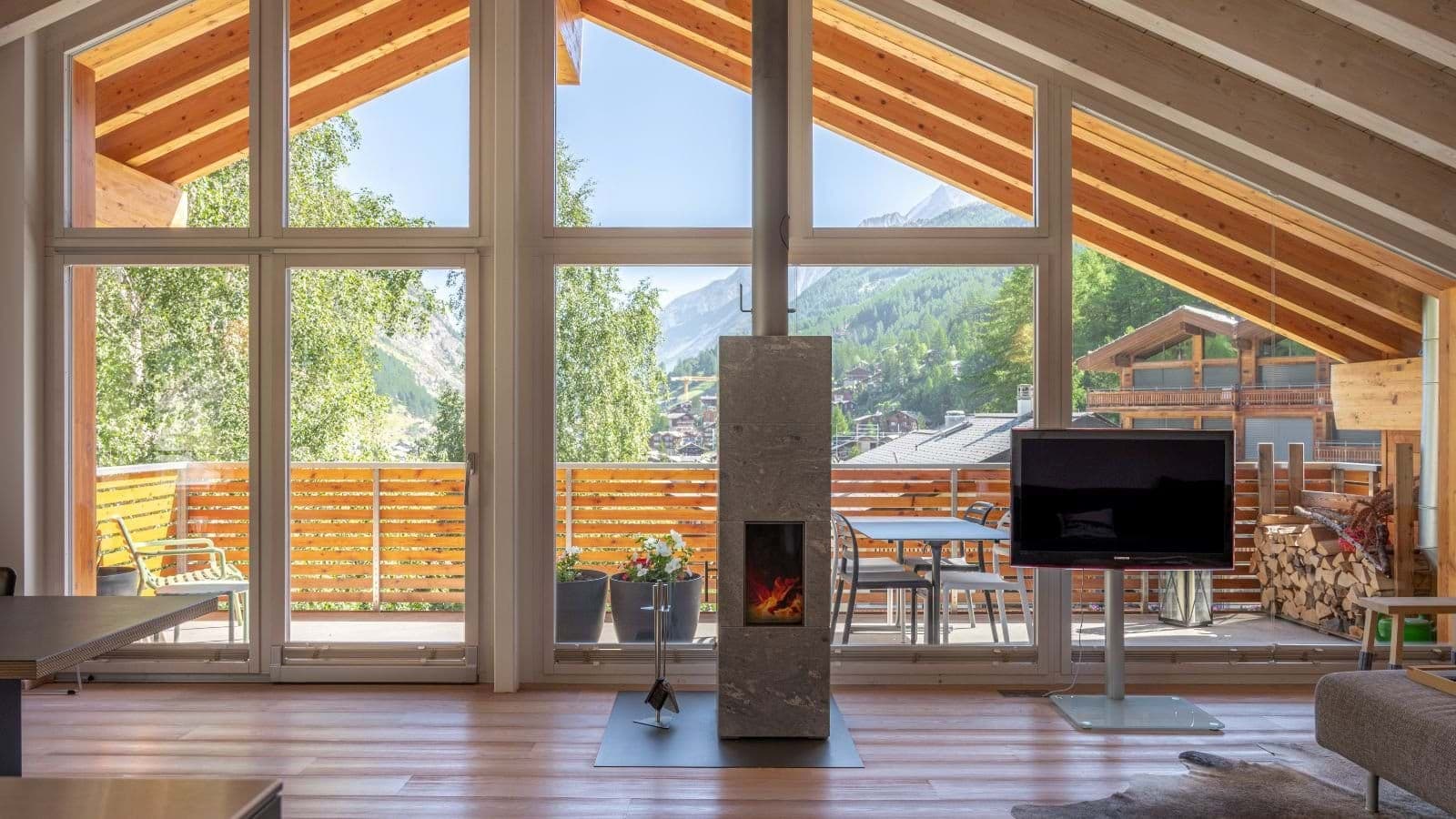 Living area with soapstone wood stove and alpine valley views