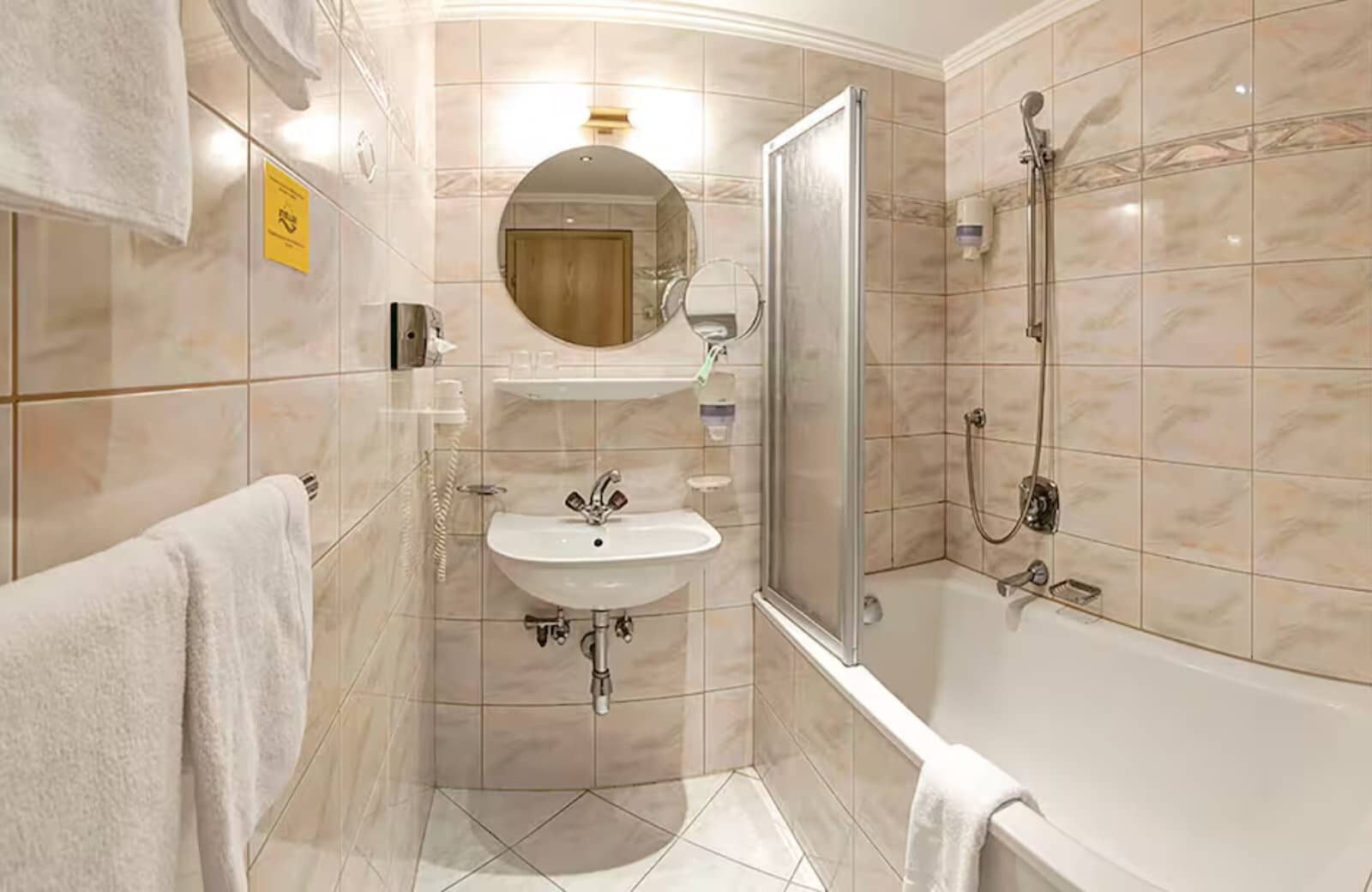 Bathroom featuring soaking tub with shower wand and wall-mounted hair dryer
