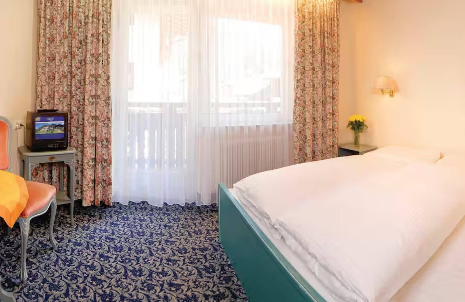 Guest bedroom with balcony access and small television