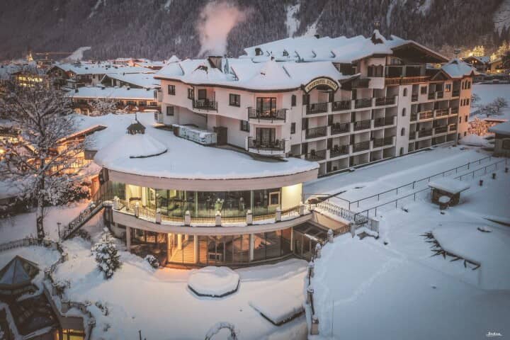 Ski-in/ski-out hotel exterior with private balconies and wrap-around terrace