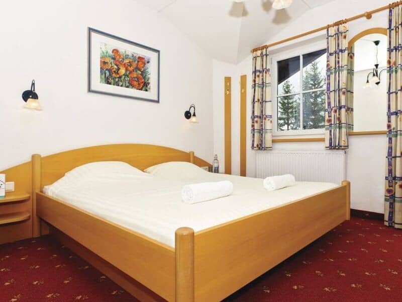 Guest bedroom with king bed and reading lights; forest views