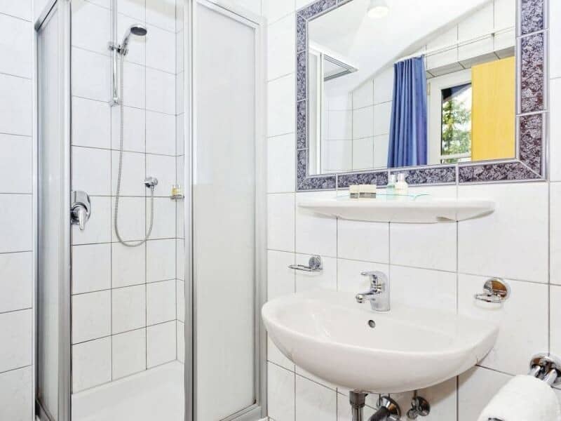 Bathroom featuring walk-in shower with adjustable handheld head and pedestal sink