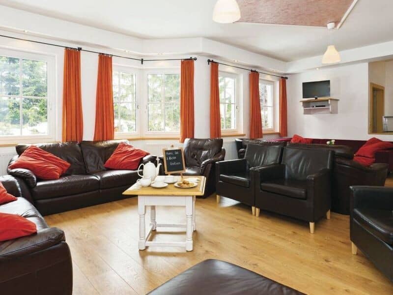 Living area with leather seating for 10 and wall-mounted TV