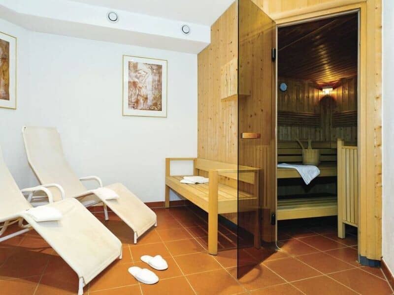 Private sauna with glass door and lounge area with recliner seating