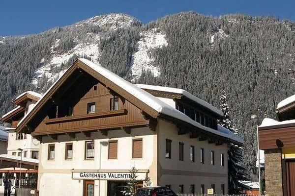 Chalet exterior with mountain backdrop and private balcony