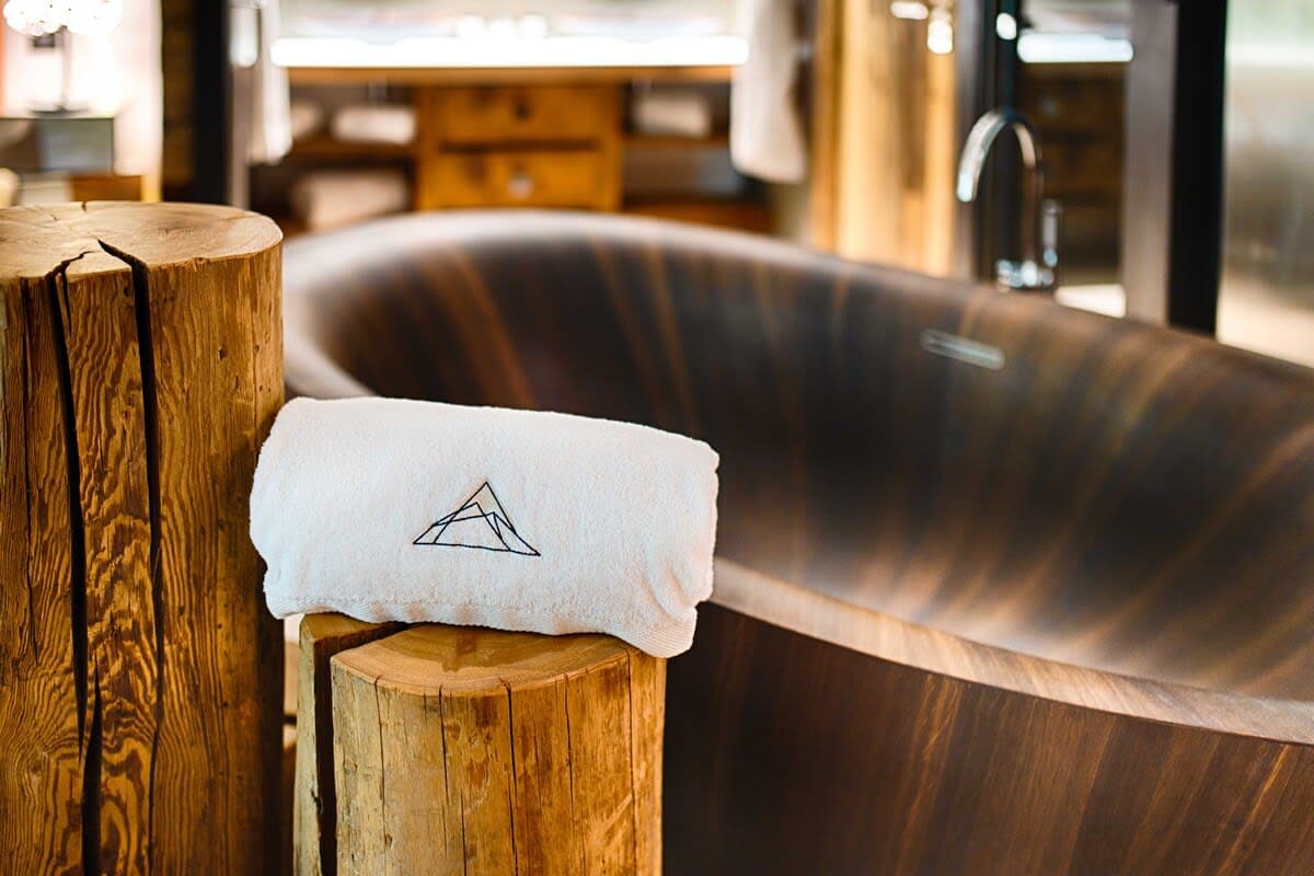 Bathroom with deep wooden soaking tub and floor-mounted faucet