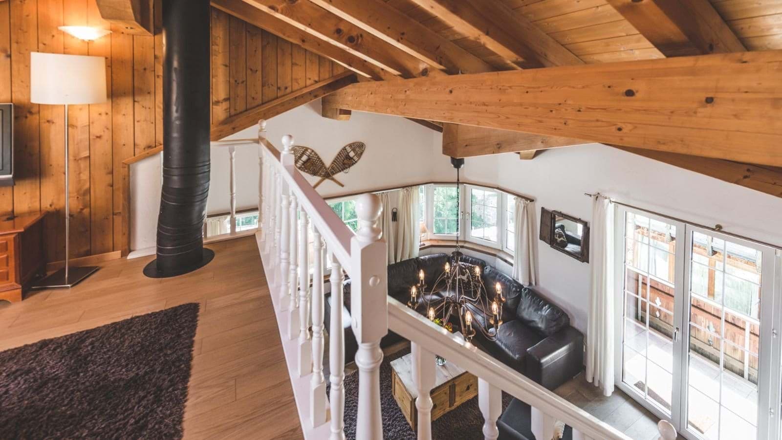 Mezzanine level overlooking living area with vaulted beam ceilings