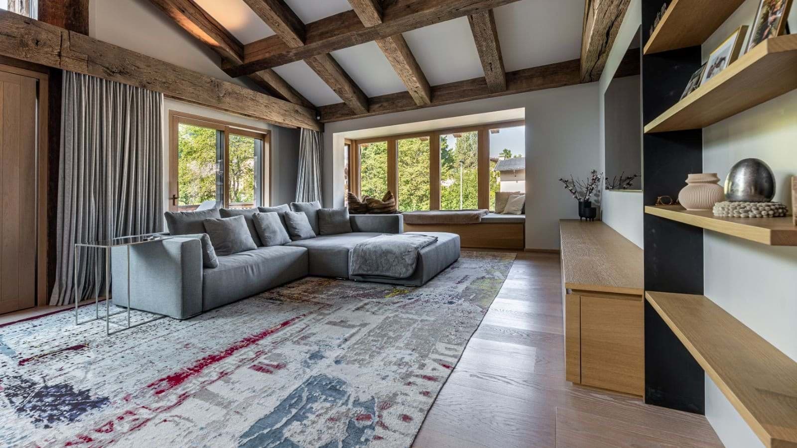 Living area with sectional seating, window nook, and vaulted timber beams