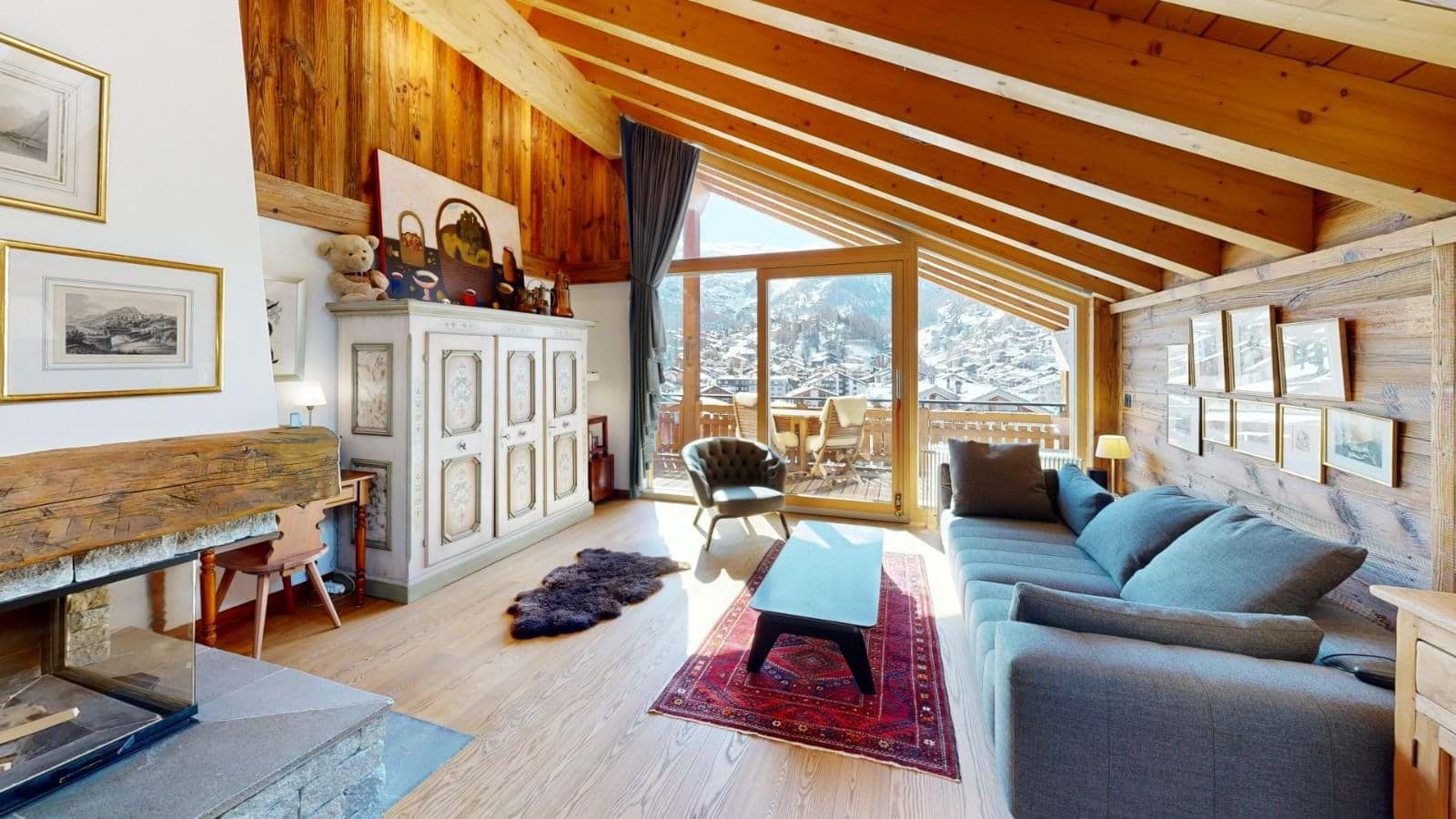 Top floor living area with wood-burning fireplace and mountain village views