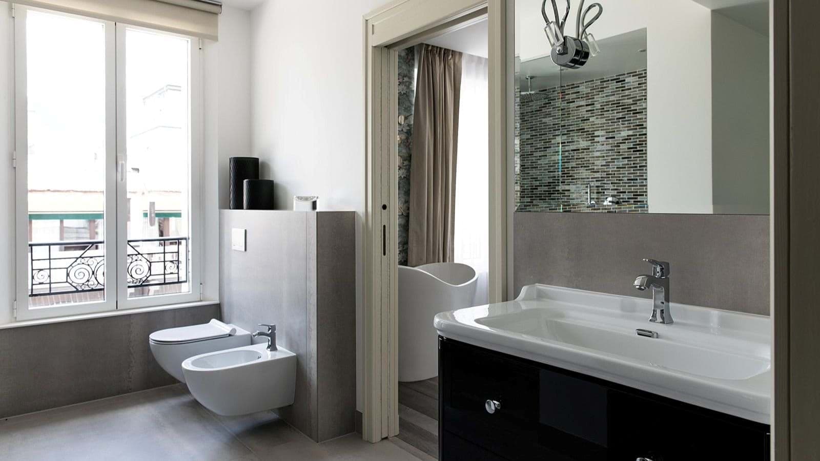 Bathroom with bidet; adjoining space features freestanding soaking tub and shower