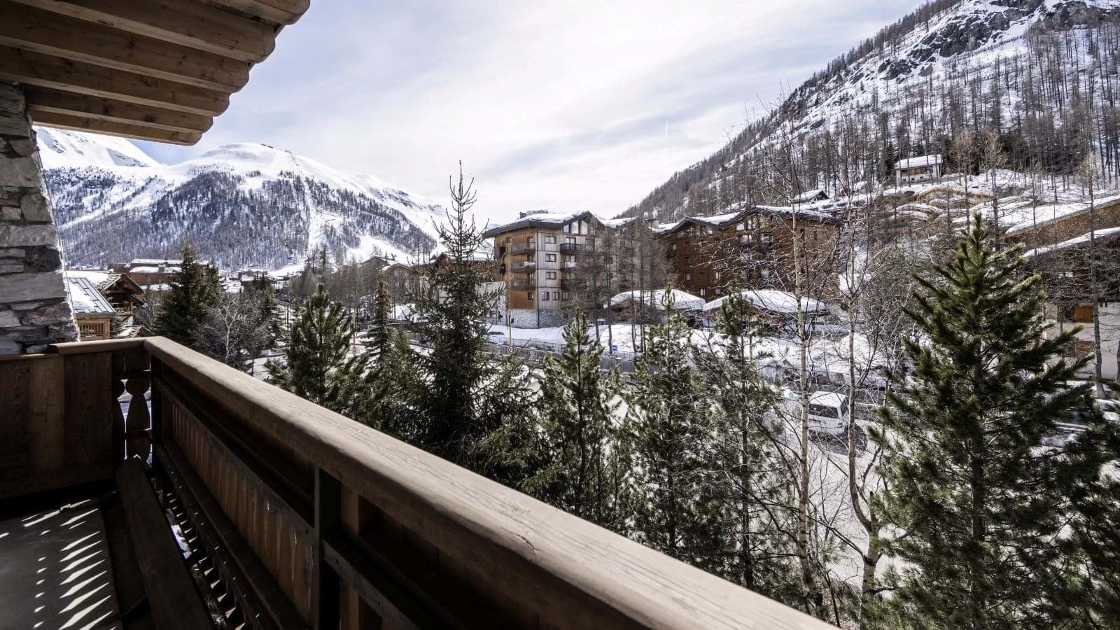 Private balcony overlooking alpine village and snowy mountain peaks