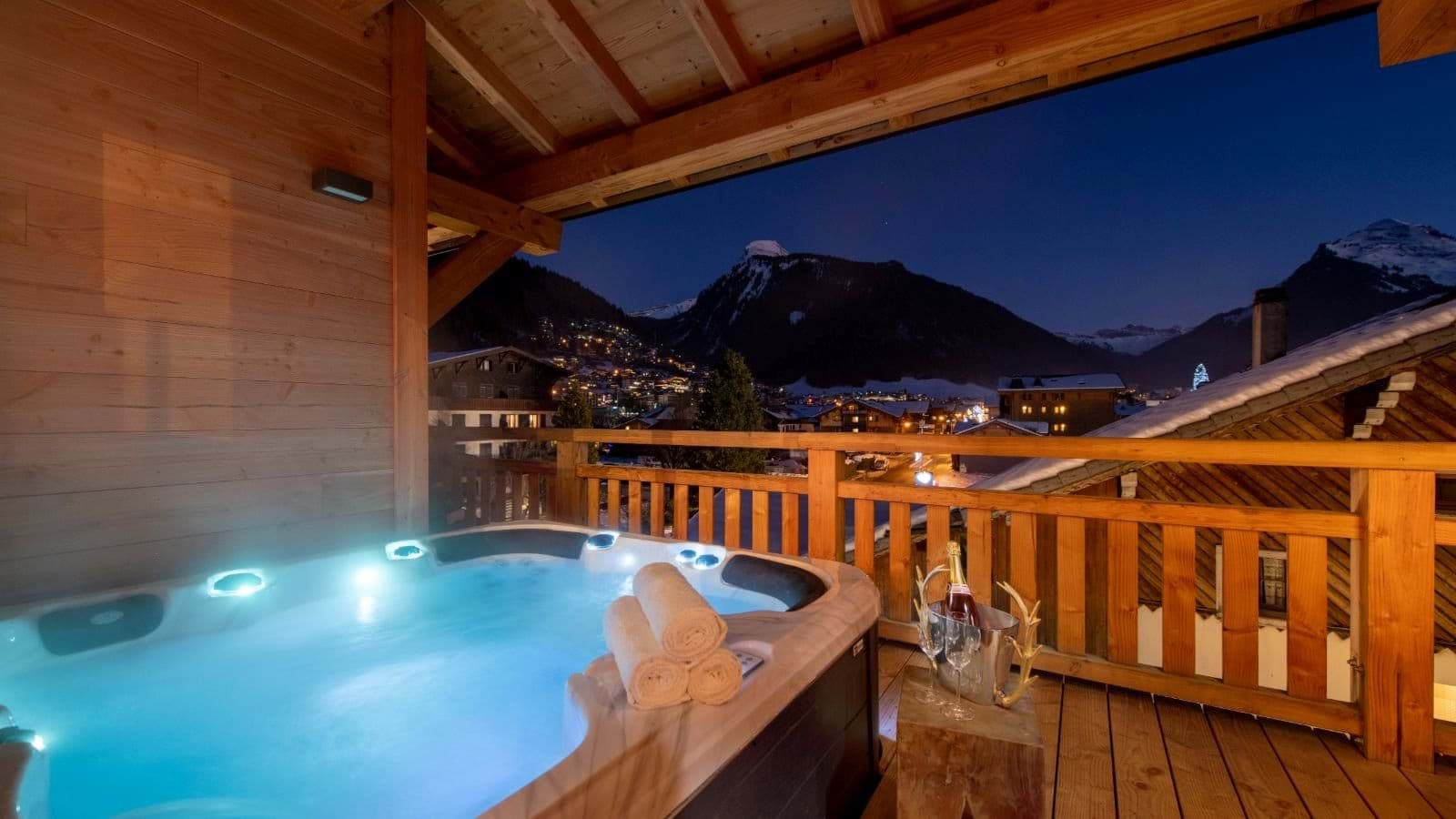 Covered balcony hot tub with village and mountain views