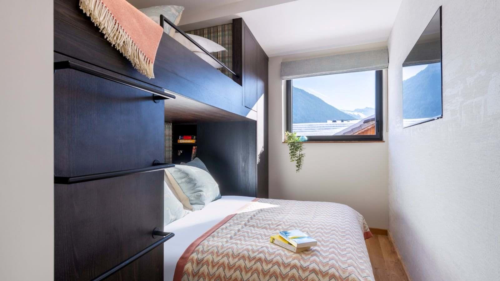 Bunk room with integrated ladder, mountain views, and wall-mounted TV