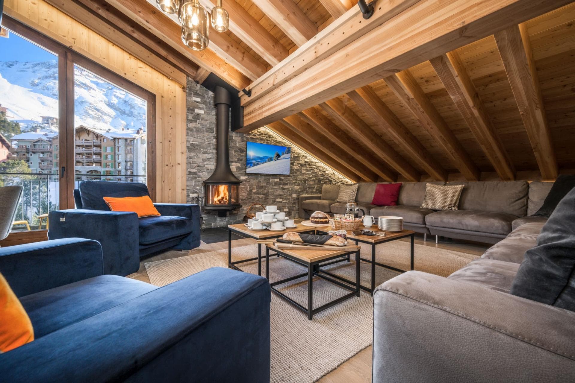 Living area with wood-burning stove and mountain resort views