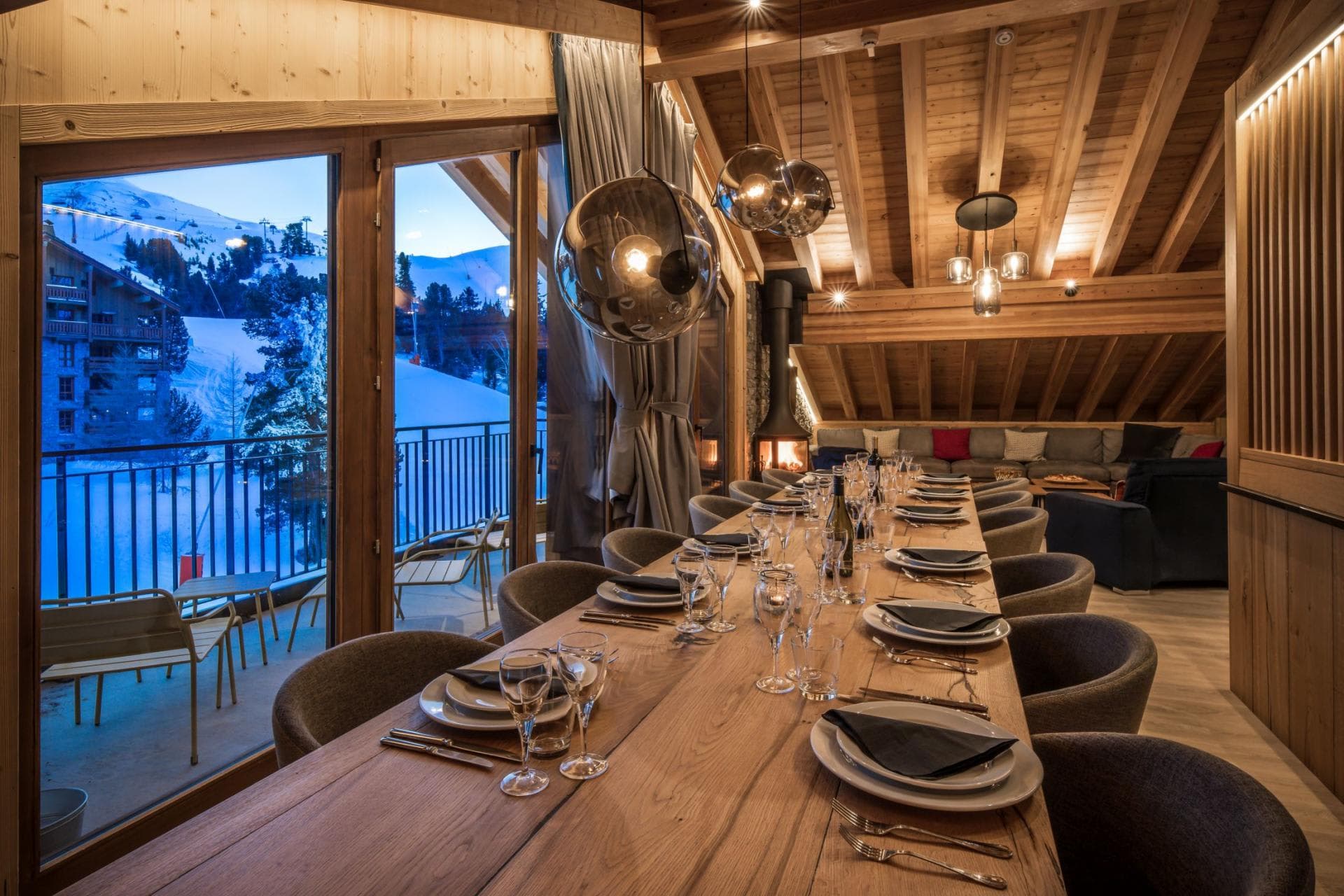 Dining table seats 12; floor-to-ceiling windows with ski slope views