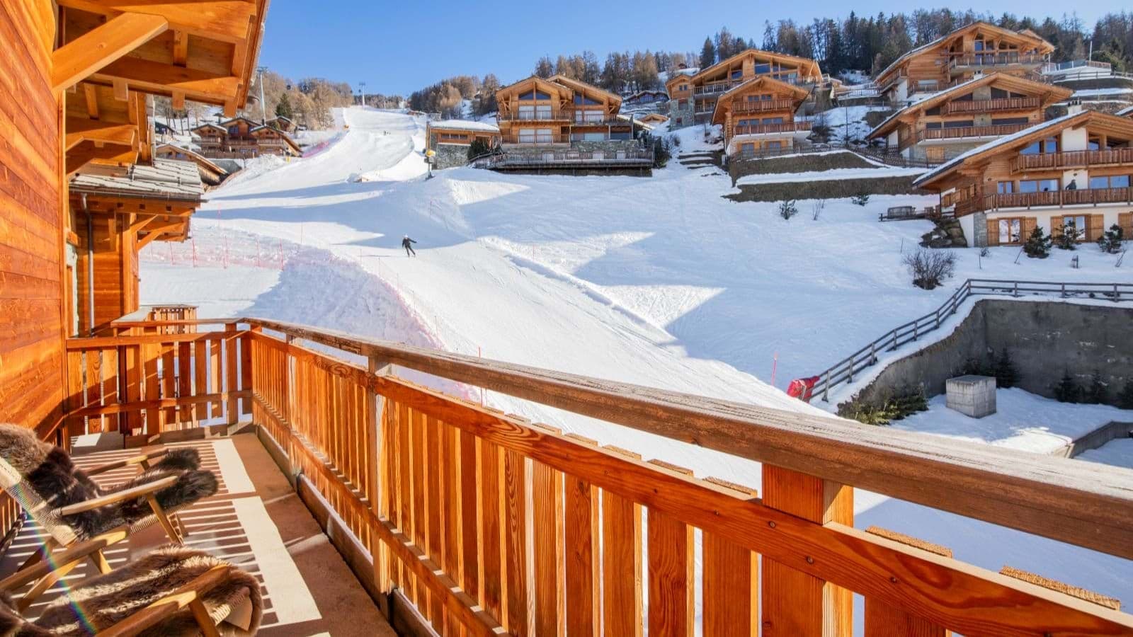 Wooden balcony overlooking ski run with direct slope access