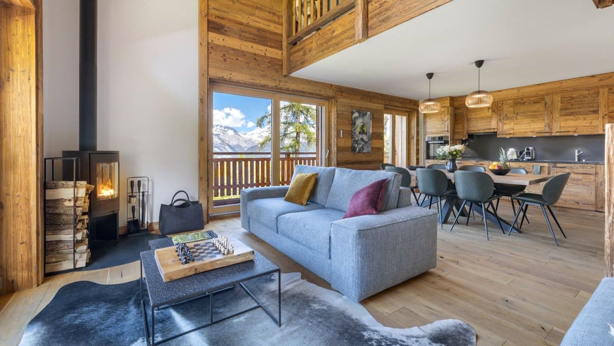 Open-plan living area with wood-burning stove and mountain views