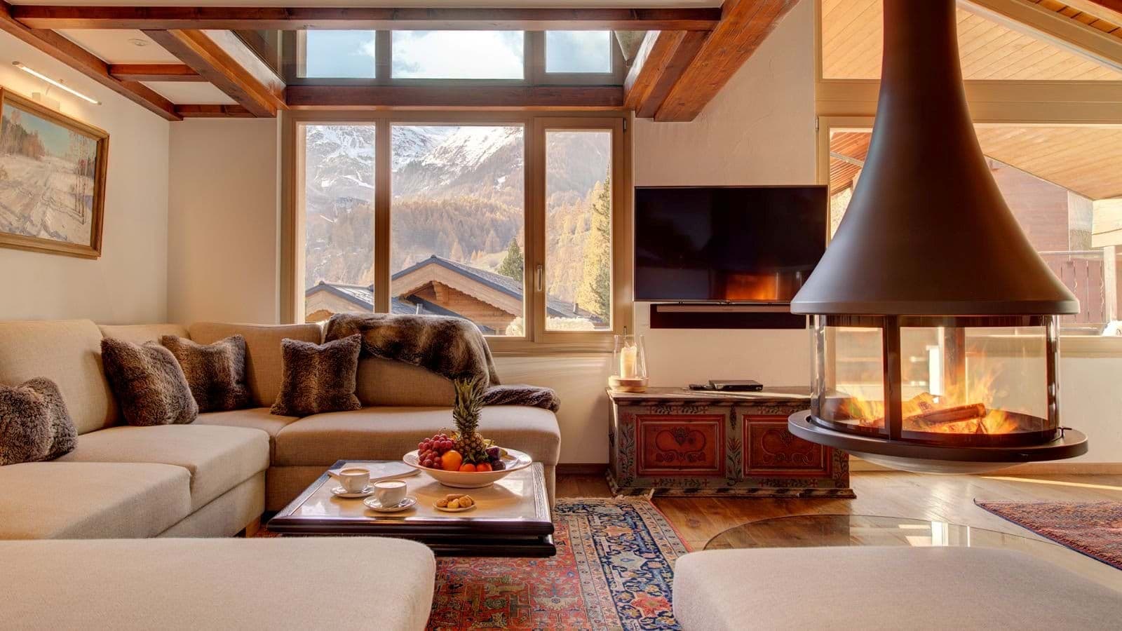 Living area with wood-burning suspended fireplace and mountain views