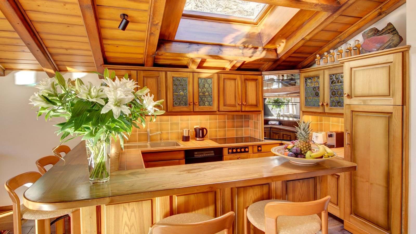 U-shaped kitchen with skylight, induction cooktop, and breakfast bar seating