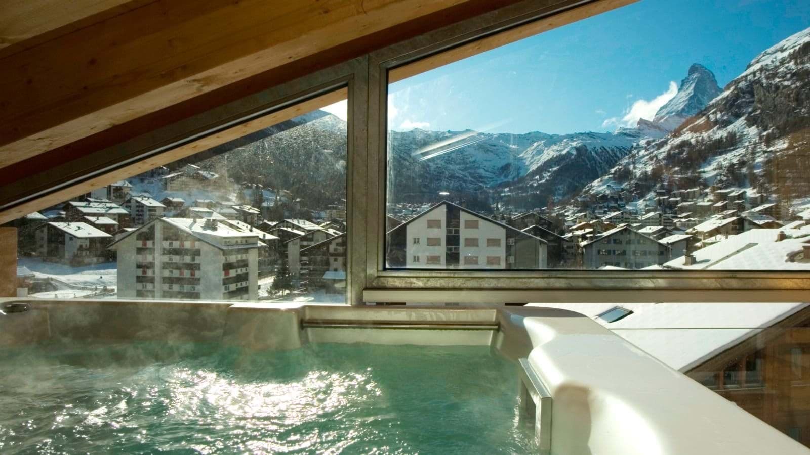 Indoor hot tub with floor-to-ceiling windows and direct Matterhorn view