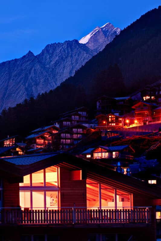 Chalet exterior at dusk with mountain peak views