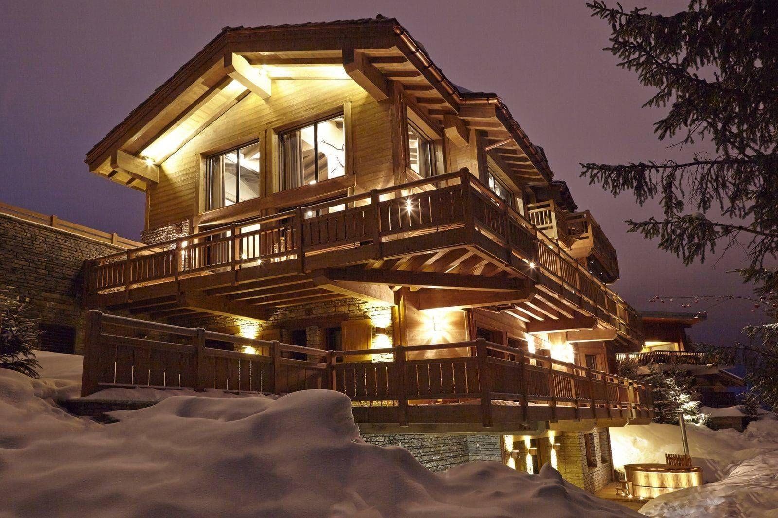 Chalet exterior with multi-level wrap-around balconies and private outdoor hot tub