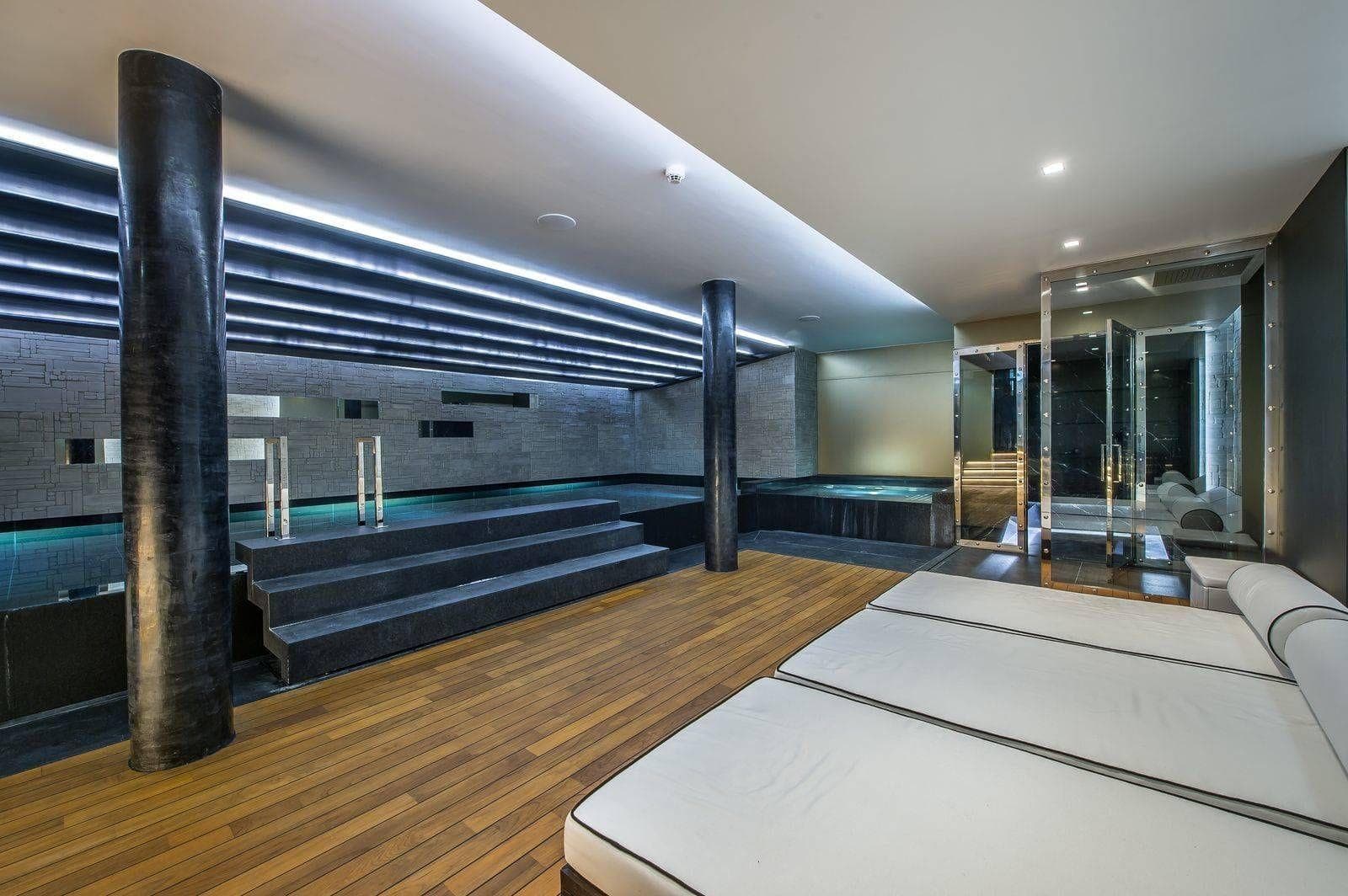 Indoor pool and spa area with hot tub, sauna, and daybeds