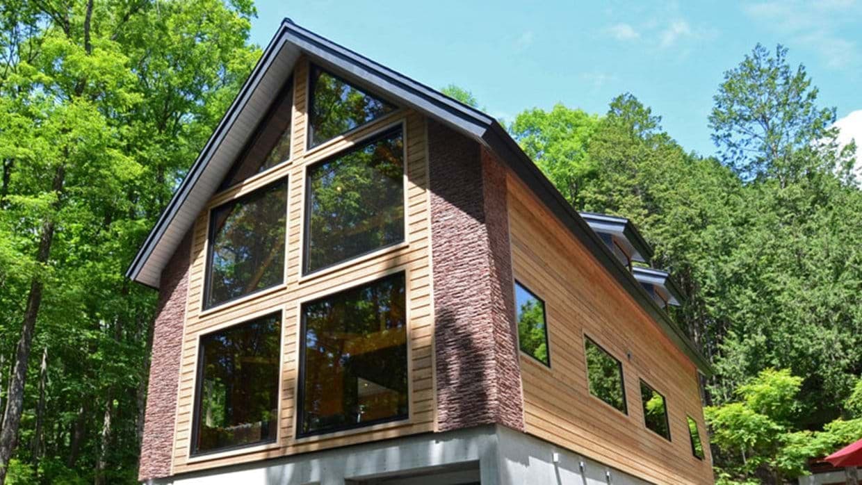 Cabin exterior featuring floor-to-ceiling windows and wood siding