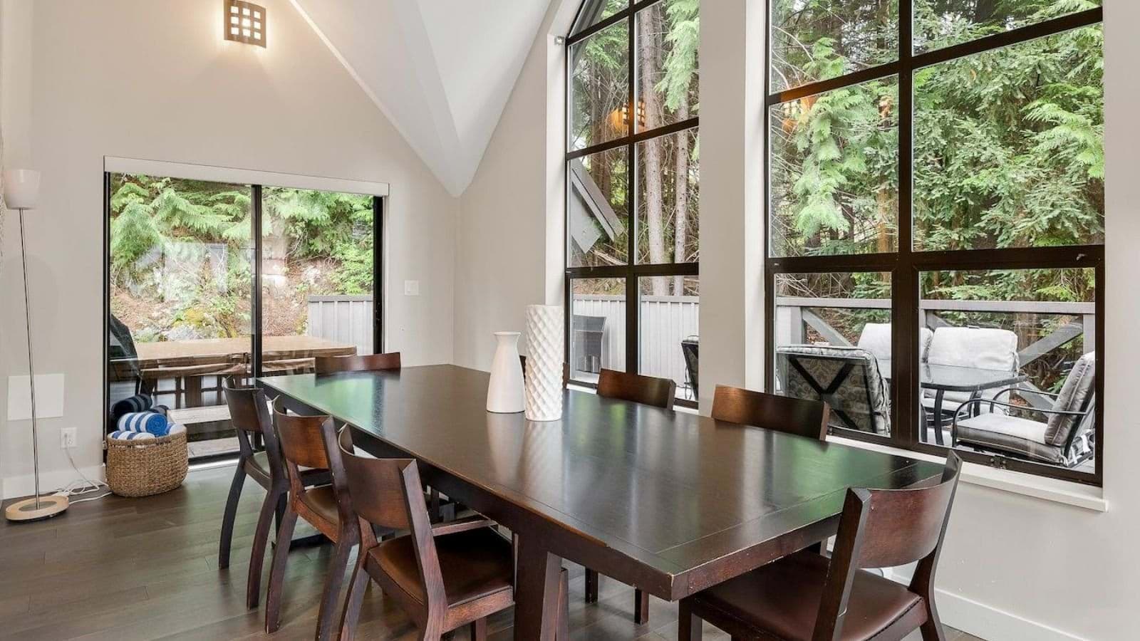 Dining area seating 8 with forest views and deck access