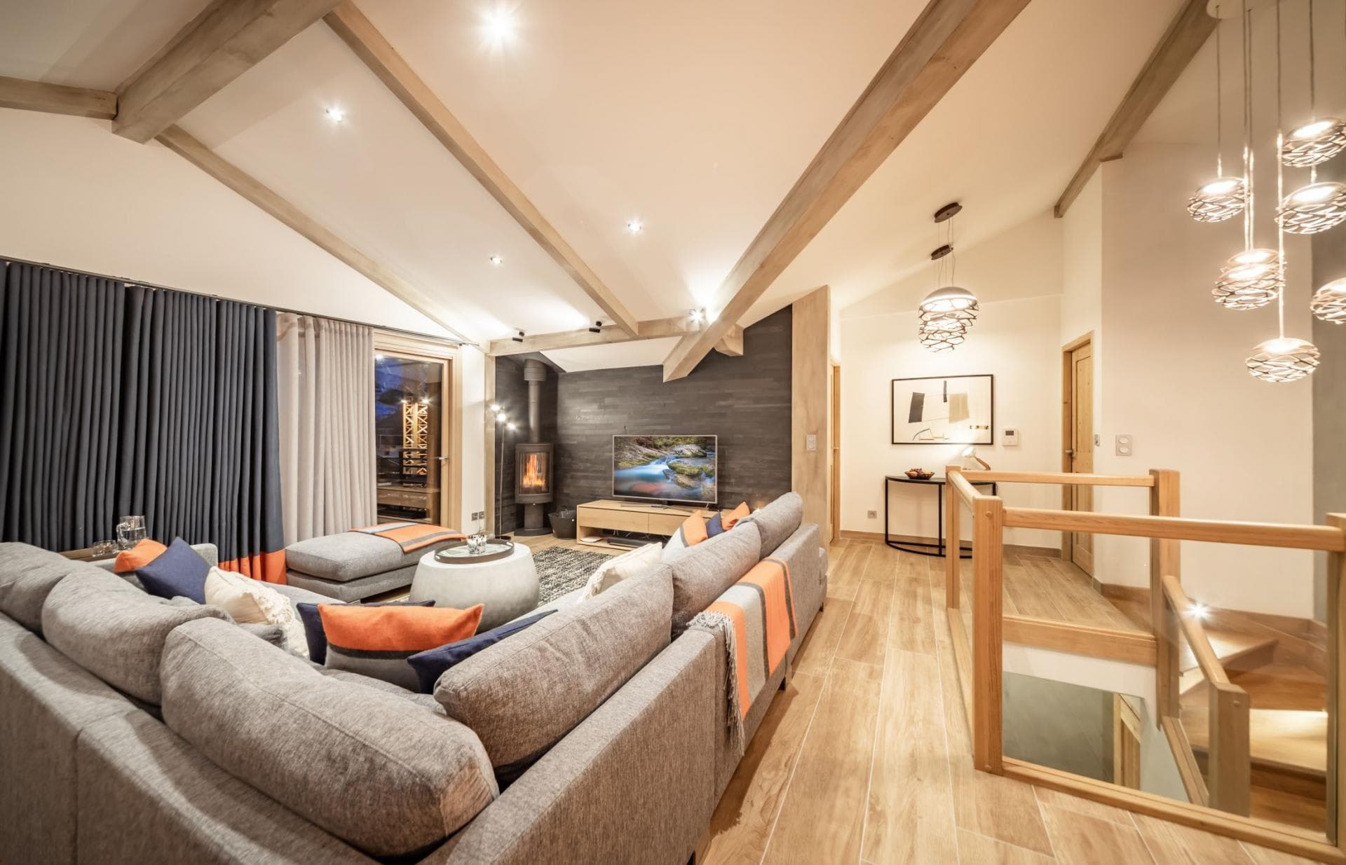 Upper floor living room with wood-burning stove and vaulted beam ceilings